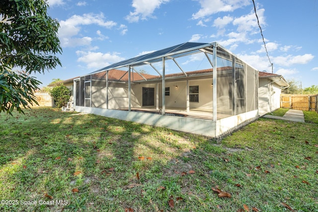 rear view of house with a lanai and a yard