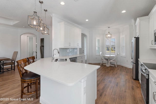 kitchen with appliances with stainless steel finishes, white cabinetry, and pendant lighting