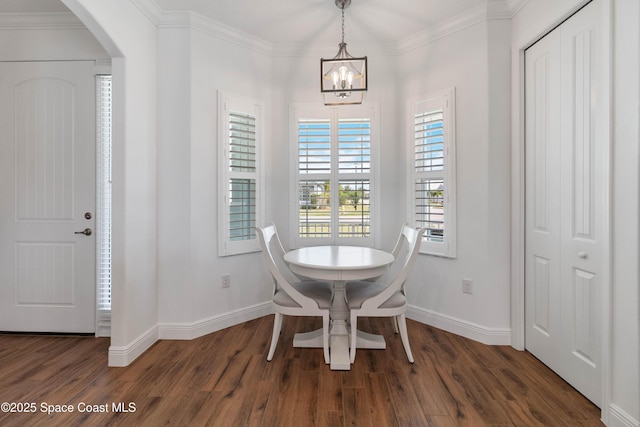 dining area featuring ornamental molding, dark wood-type flooring, and a notable chandelier