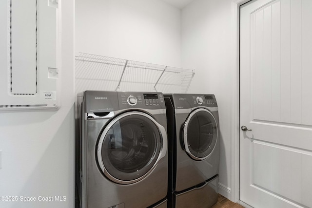 laundry room featuring washer and clothes dryer and hardwood / wood-style floors