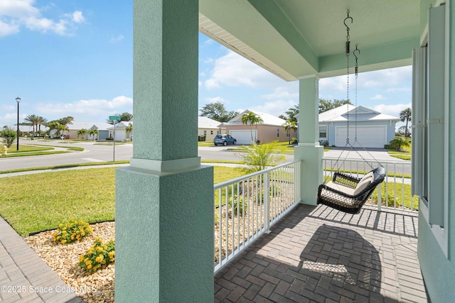 view of patio / terrace with a porch and a garage