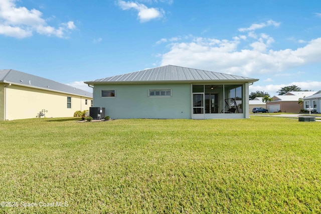 back of house featuring a lawn, a sunroom, and central AC