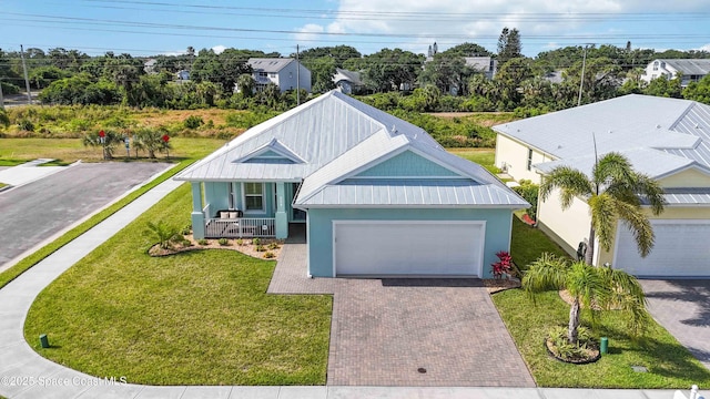 view of front of house featuring a porch, a garage, and a front lawn