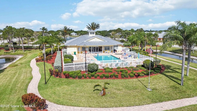 view of swimming pool featuring a yard, a water view, and a patio