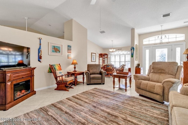 living room featuring a textured ceiling, lofted ceiling, a notable chandelier, and light tile patterned flooring