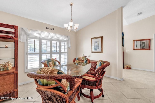 dining space featuring vaulted ceiling, light tile patterned floors, and an inviting chandelier