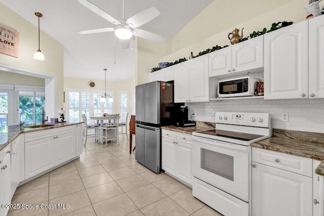 kitchen featuring decorative light fixtures, white cabinetry, white appliances, and vaulted ceiling