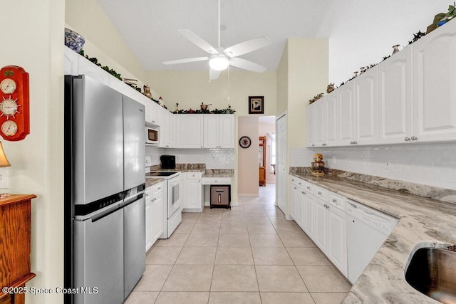 kitchen with light stone countertops, white appliances, ceiling fan, white cabinets, and light tile patterned flooring