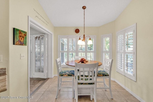 tiled dining space with a chandelier