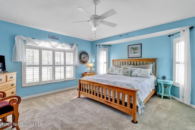 carpeted bedroom featuring ceiling fan and a textured ceiling