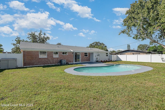 view of swimming pool featuring a lawn, a patio, and central AC