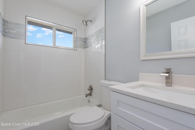 full bathroom with tiled shower / bath, vanity, and toilet