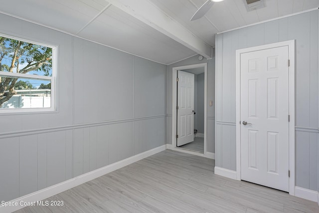 empty room featuring beamed ceiling, light wood-type flooring, and ceiling fan