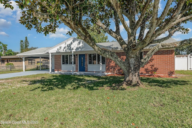 ranch-style house featuring a front lawn and a carport