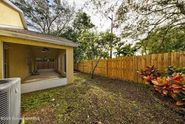 view of yard featuring ceiling fan and central AC