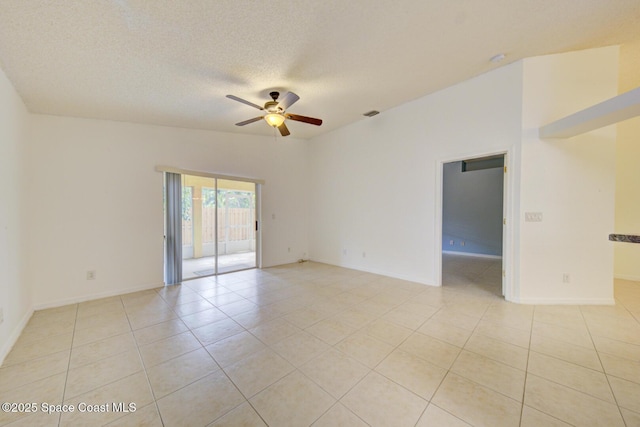 empty room featuring ceiling fan, light tile patterned floors, and a textured ceiling