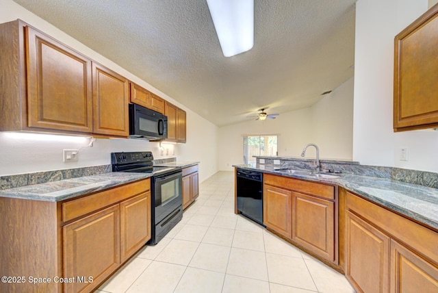 kitchen with light stone counters, vaulted ceiling, ceiling fan, sink, and black appliances