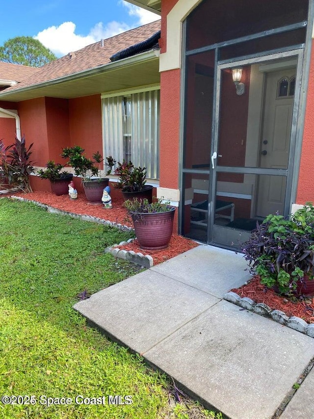 doorway to property with a lawn