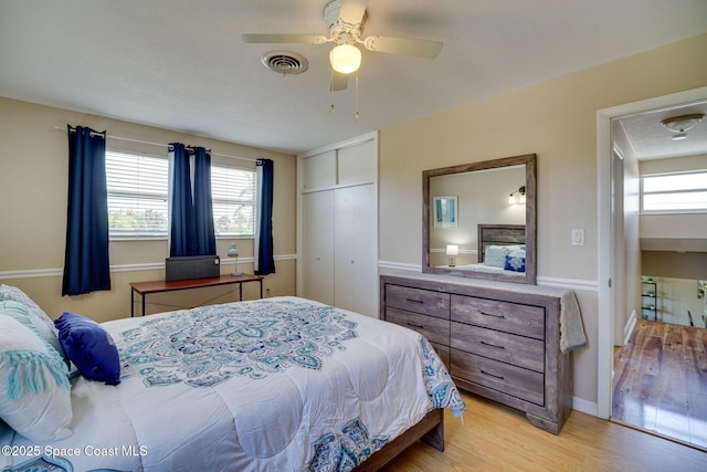 bedroom with a textured ceiling, a closet, ceiling fan, and light hardwood / wood-style floors