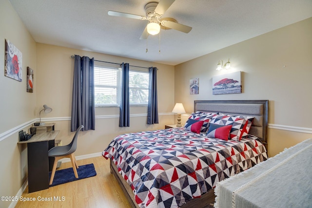 bedroom with ceiling fan, a textured ceiling, and light wood-type flooring