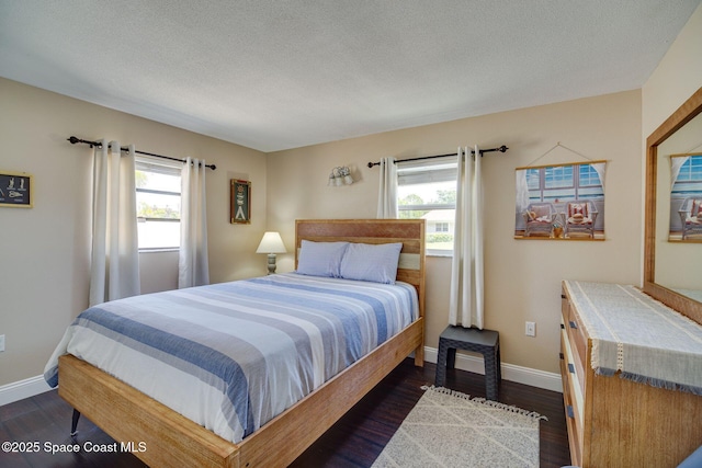 bedroom with a textured ceiling and dark wood-type flooring