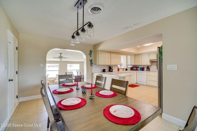 dining room with sink, a textured ceiling, ceiling fan, and light tile patterned flooring