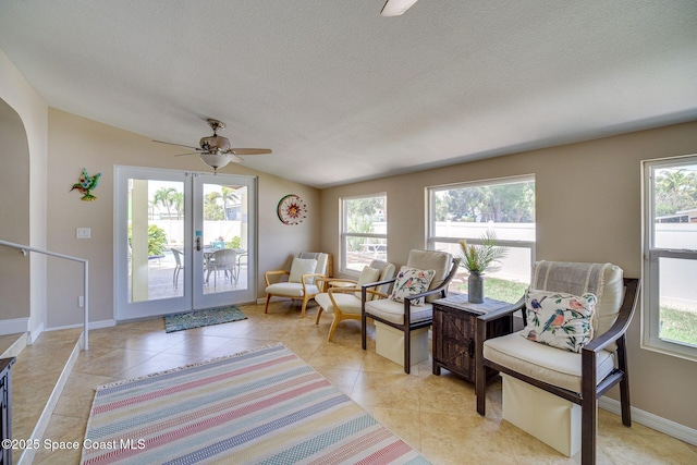 sitting room featuring ceiling fan, light tile patterned floors, a textured ceiling, and lofted ceiling