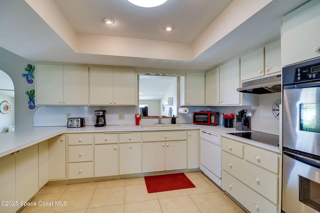 kitchen with a raised ceiling, sink, light tile patterned floors, and black appliances