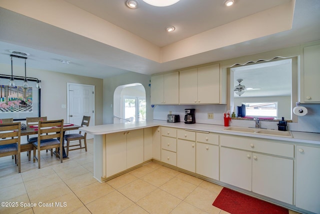 kitchen featuring ceiling fan, kitchen peninsula, sink, and a wealth of natural light