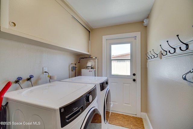 laundry area featuring cabinets, light tile patterned floors, and washer and dryer