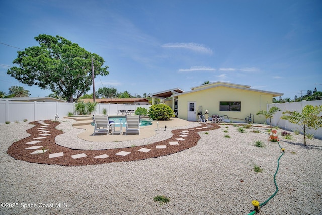 back of property featuring a patio area and a fenced in pool