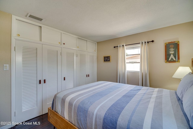 bedroom featuring dark hardwood / wood-style floors and a textured ceiling