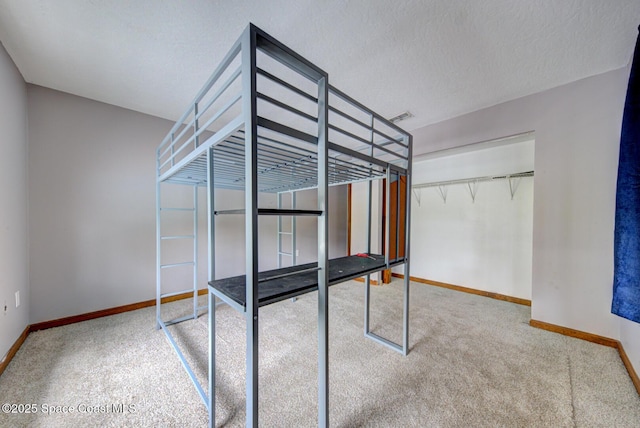 unfurnished bedroom with carpet flooring, a closet, and a textured ceiling