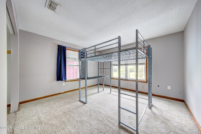 unfurnished bedroom with carpet and a textured ceiling