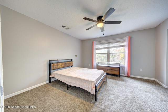 carpeted bedroom featuring a textured ceiling and ceiling fan