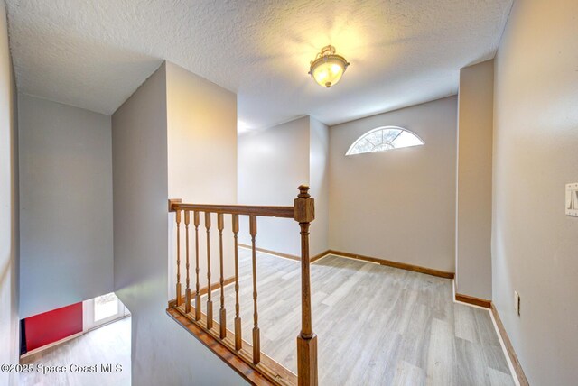 interior space featuring light wood-type flooring and a textured ceiling