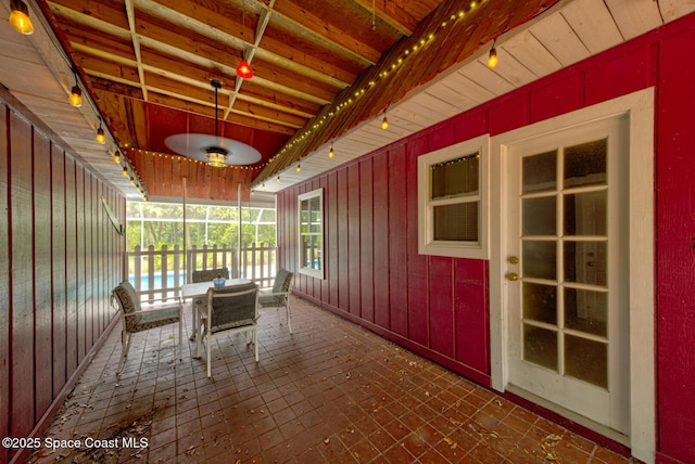 unfurnished sunroom featuring beamed ceiling