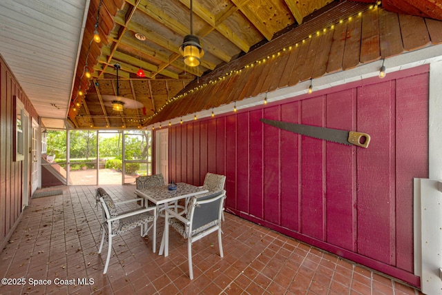 unfurnished sunroom featuring lofted ceiling with beams