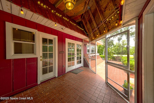 unfurnished sunroom featuring ceiling fan and vaulted ceiling