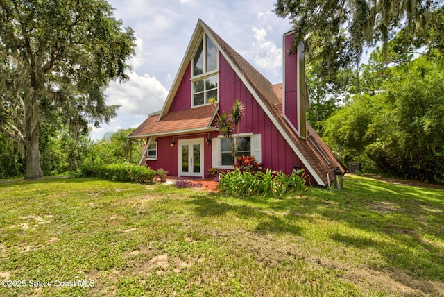 back of house featuring a lawn, french doors, and cooling unit