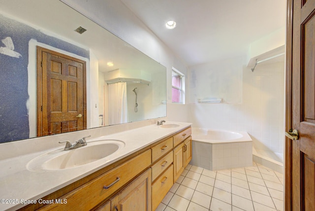 bathroom with tile patterned floors, tiled tub, and vanity