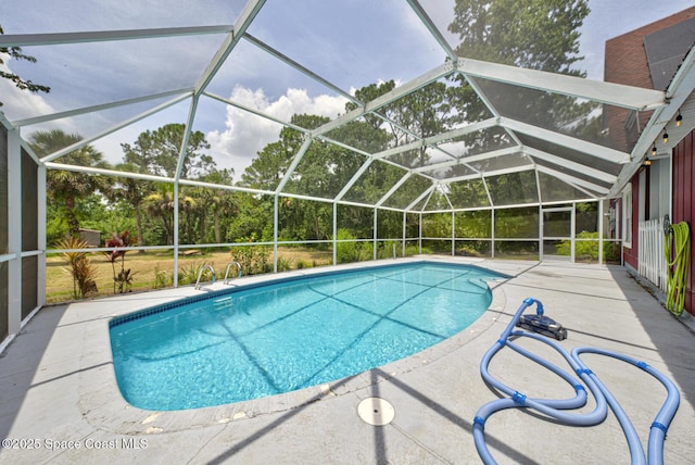 view of swimming pool featuring a lanai and a patio area