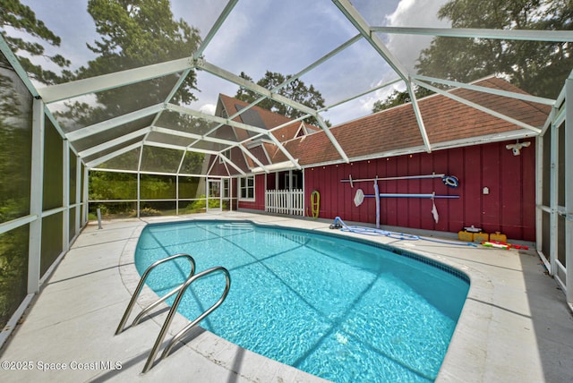 view of swimming pool with glass enclosure and a patio