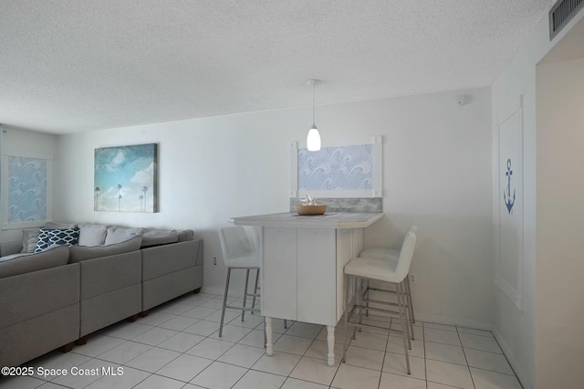 tiled dining area featuring a textured ceiling