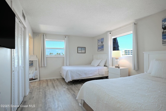 bedroom featuring light hardwood / wood-style flooring and a textured ceiling