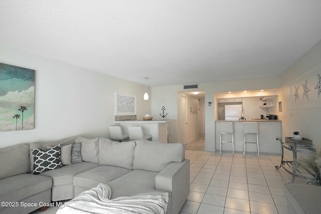 living room with light tile patterned floors and a textured ceiling