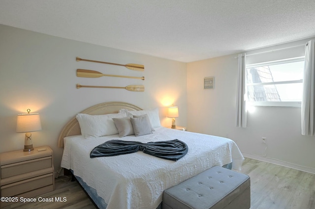 bedroom featuring hardwood / wood-style floors and a textured ceiling