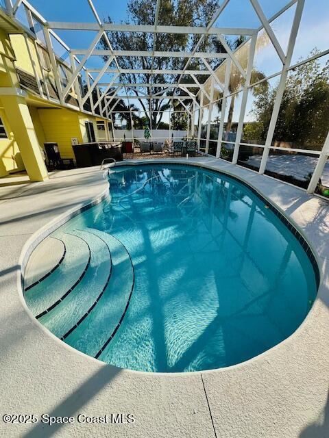 view of pool with a lanai and a patio