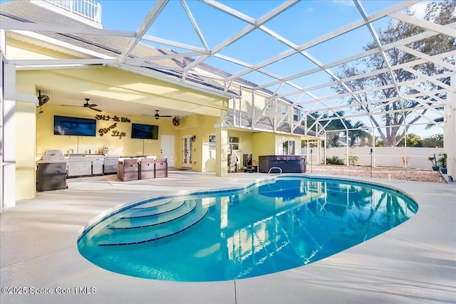 view of pool with a patio area, area for grilling, a hot tub, glass enclosure, and ceiling fan