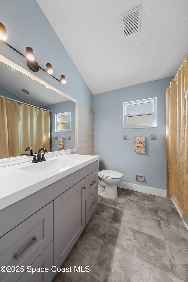 bathroom with lofted ceiling, toilet, and vanity